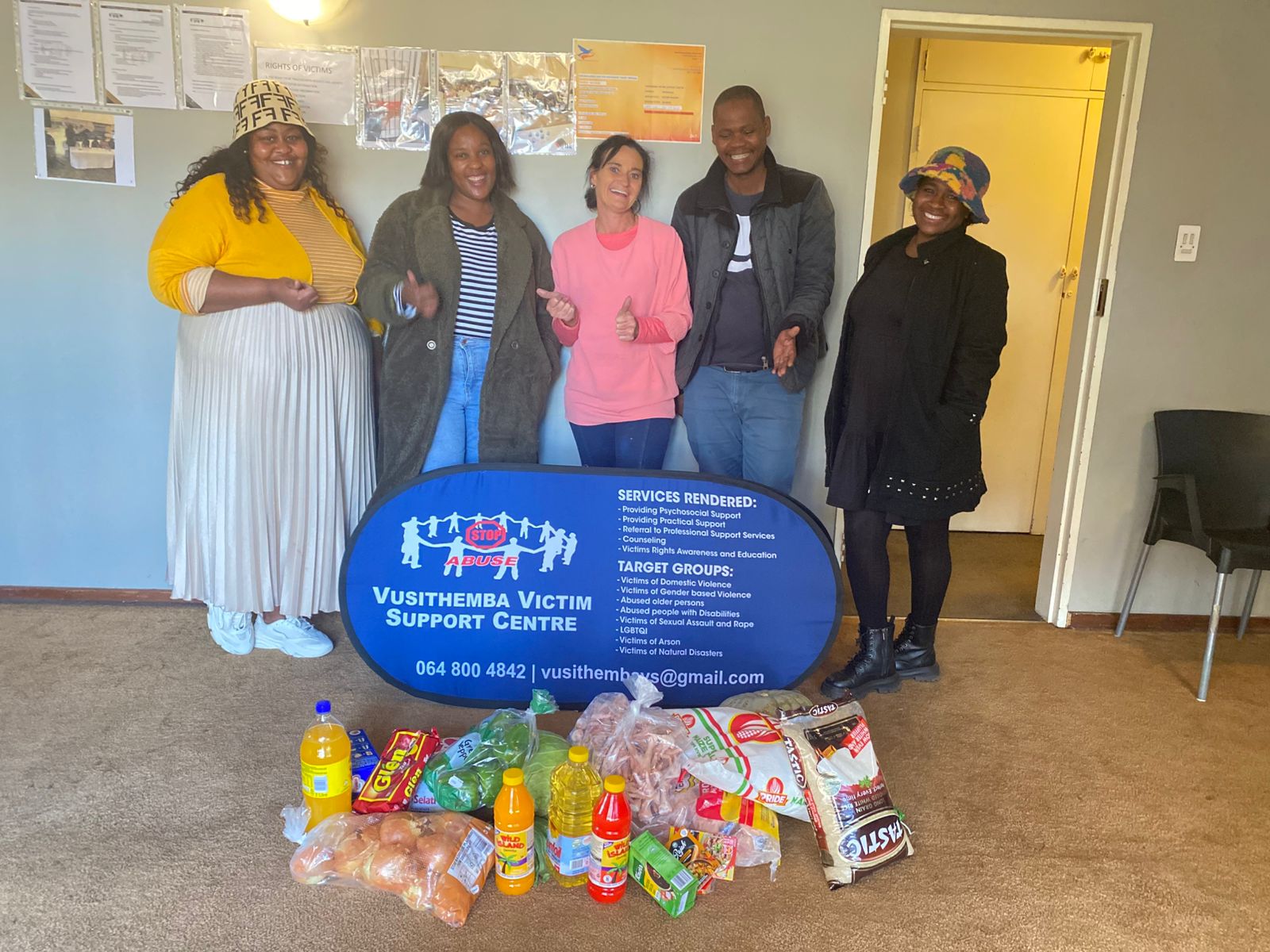 Partner visitors and Vusithemba staff standing with supplies